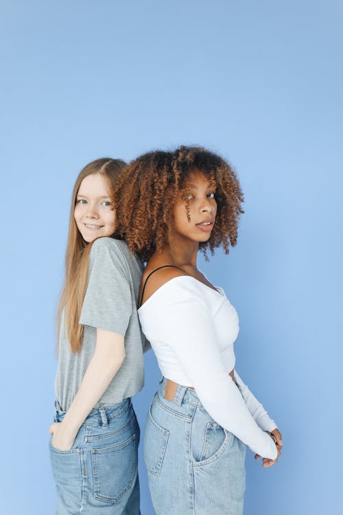 Woman and a Girl Standing Back to Back 