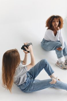 Two women enjoying a fun indoor photography session, capturing memories together.