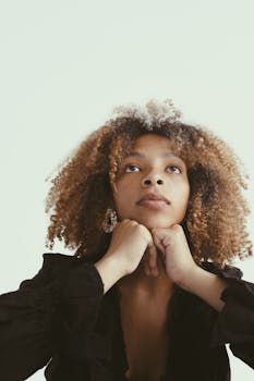 一位陷入沉思的年轻卷发非裔美国女性特写肖像