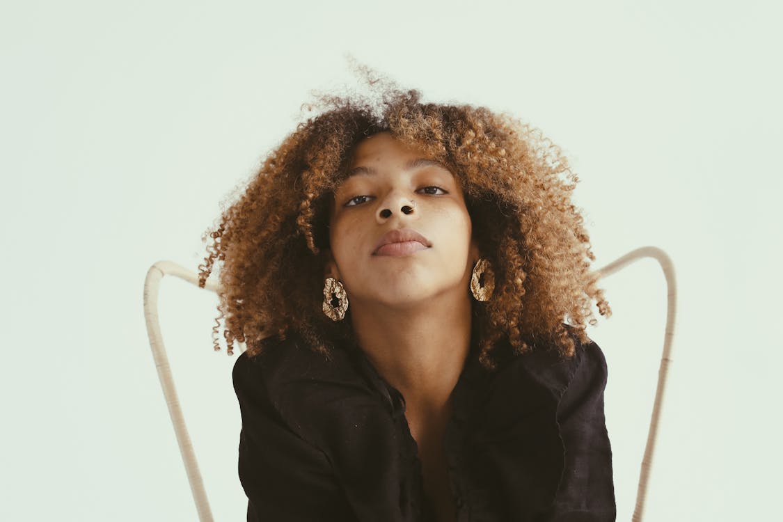 Femme En Veste Noire Assise Sur Une Chaise Blanche