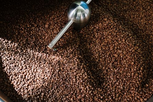 Free Detailed image of roasted coffee beans spinning inside a professional coffee roaster. Stock Photo