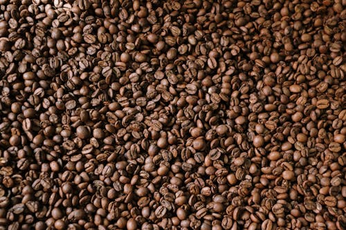 Коричневые кофейные зерна на коричневой деревянной поверхности