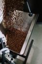 特写镜头展示了咖啡豆倒入烘焙机的过程，呈现了工业咖啡生产