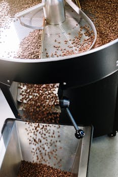 Close-up of coffee beans roasting in an industrial machine, highlighting the roasting process.