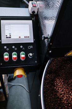 咖啡烘焙机特写，带有数字控制面板和新鲜烘焙咖啡豆