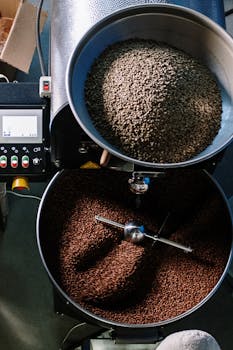 Top view of a coffee roasting machine processing beans in a workshop.
