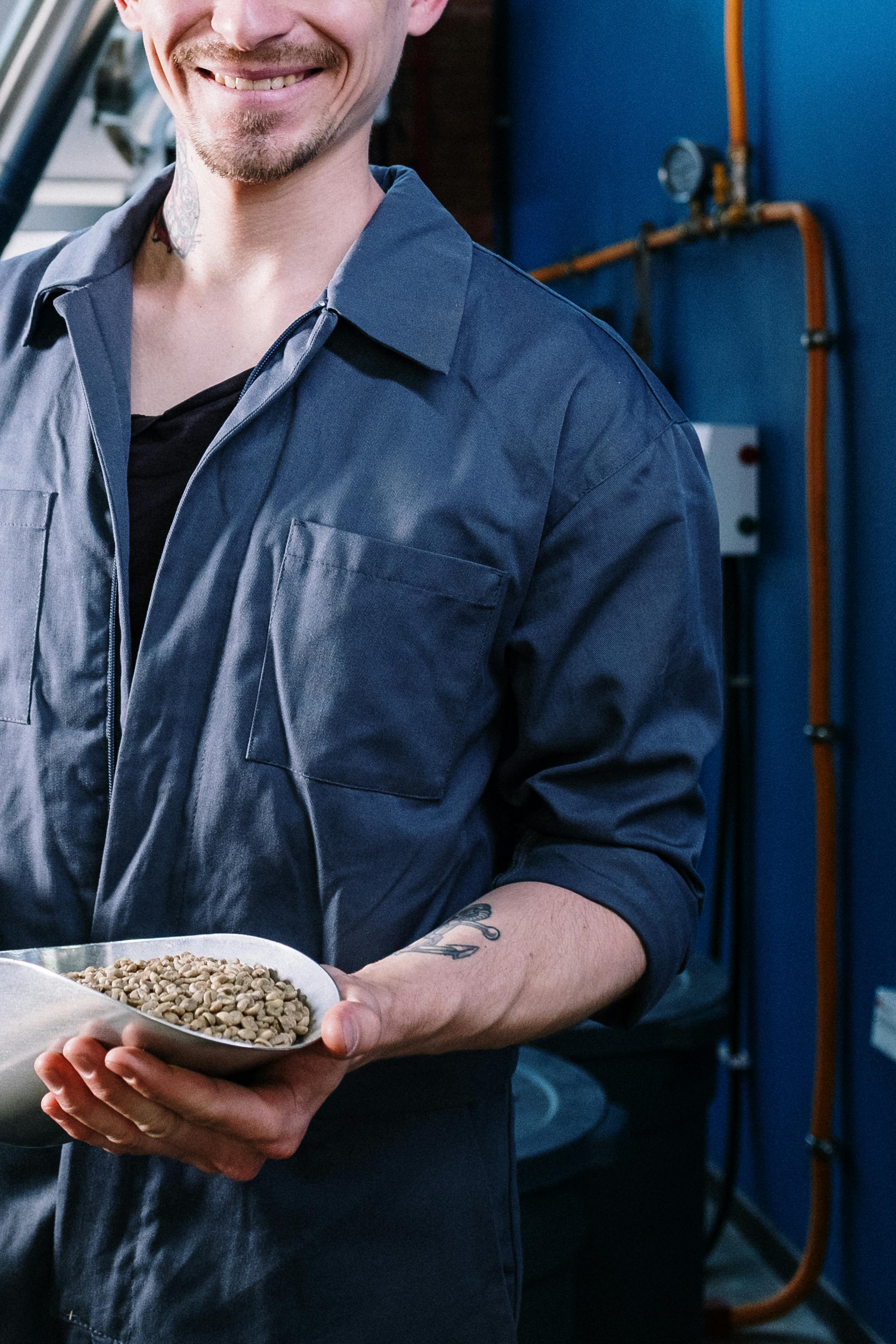 man in blue button up shirt holding white ceramic bowl