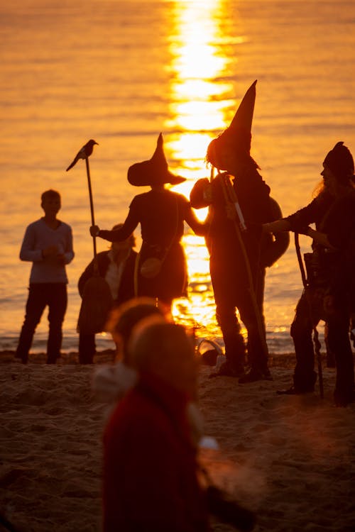 Group of People Dancing on Beach at Sunset