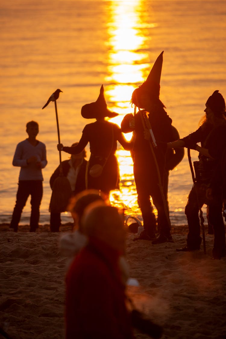 Group Of People Dancing On Beach At Sunset