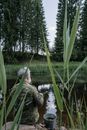 Person in Brown Jacket Sitting on Brown Wooden Log on River