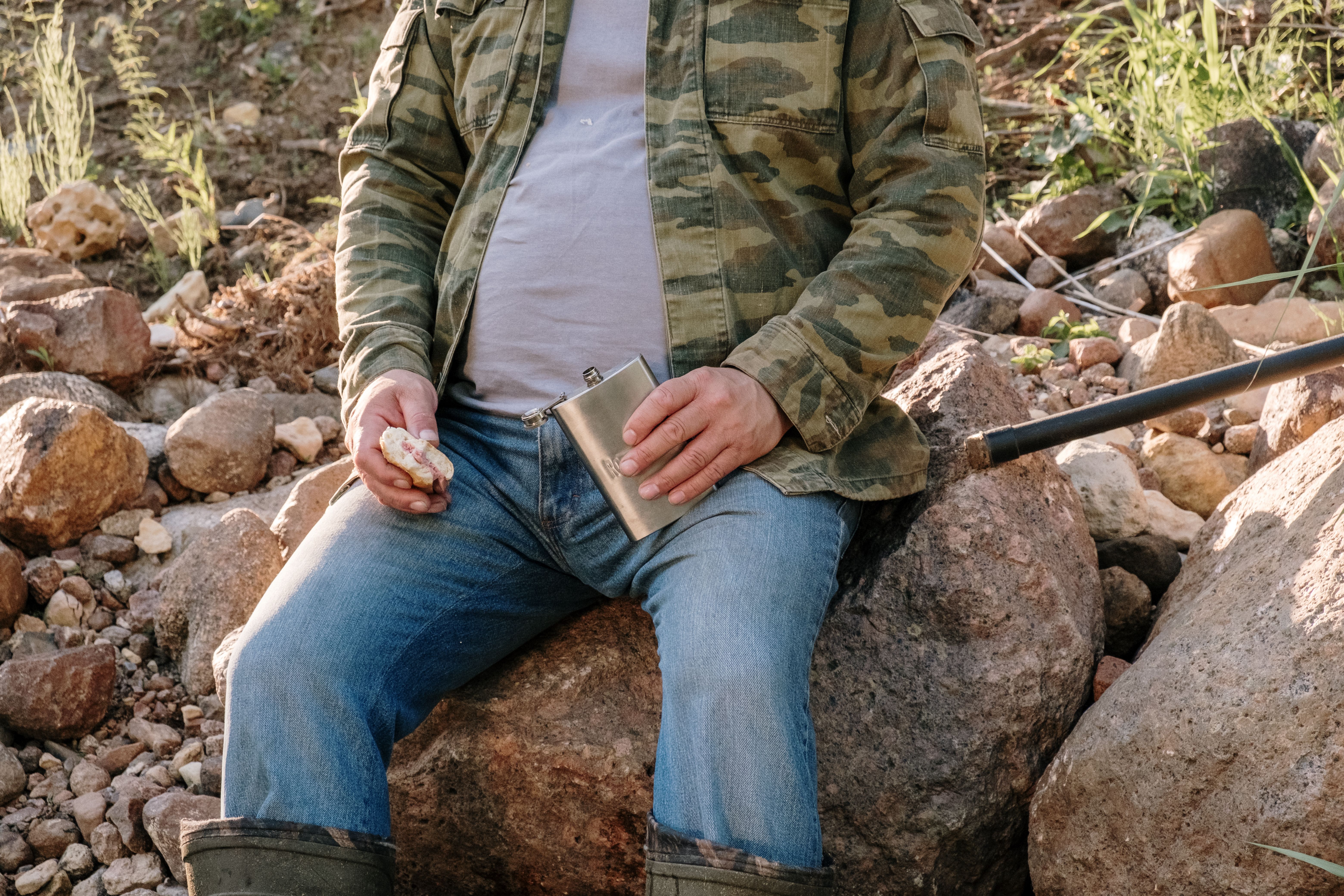 Man in Green Jacket Sitting on Rock · Free Stock Photo