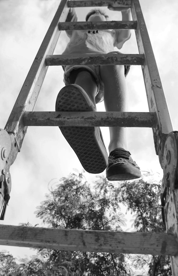 Low Angle Shot Of Child Climbing On A Ladder