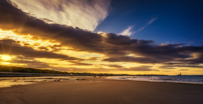 A moody sunset casting golden hues over a serene beach, perfect for stunning visuals.