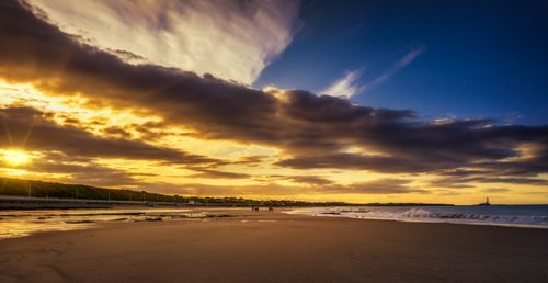 Free A moody sunset casting golden hues over a serene beach, perfect for stunning visuals. Stock Photo