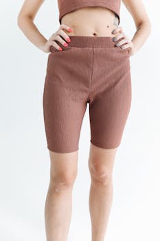 Close-up of a woman in stylish brown shorts and top, showcasing activewear fashion.