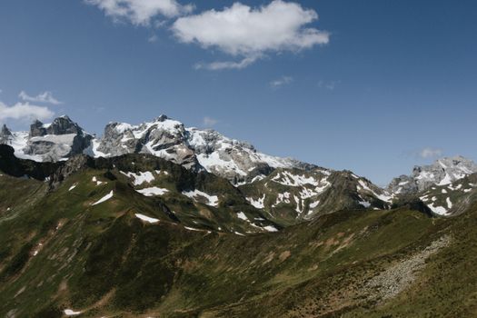 A scenic view of snow-capped mountains under a clear blue sky in Austria's Alps.