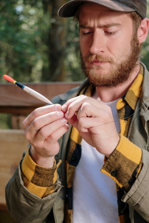 Man in Yellow and Brown Jacket Holding White Cigarette Stick