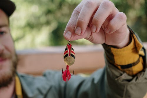 Person Holding Red and Yellow Heart Ornament