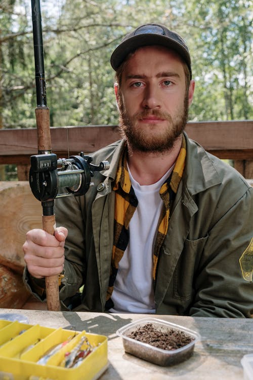 Man in Brown Jacket Holding Black and Gray Camera