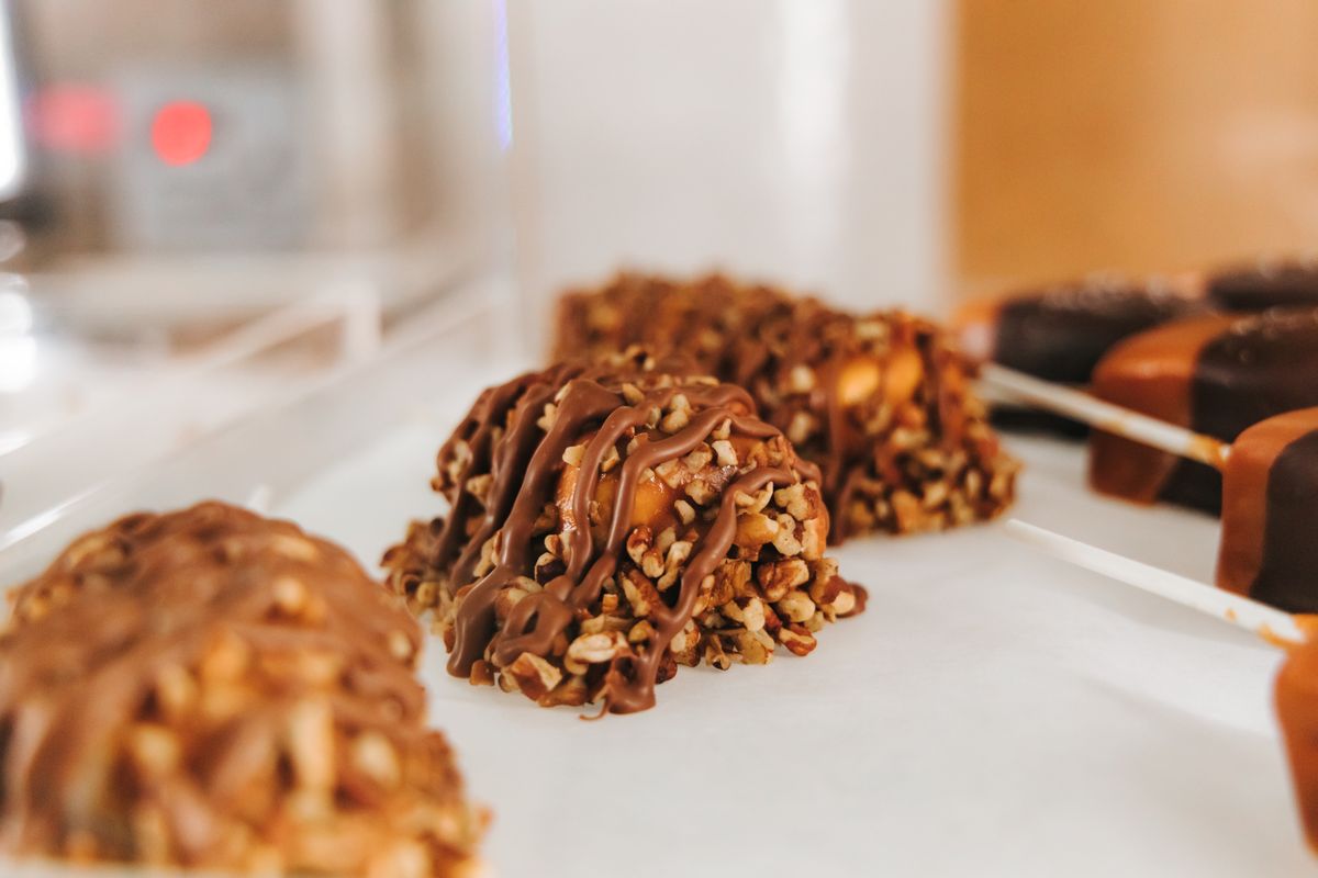 Indulge in a close-up of chocolate and nut-coated candies, perfect for dessert lovers.