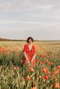 Woman in Green Dress Standing on Red Flower Field