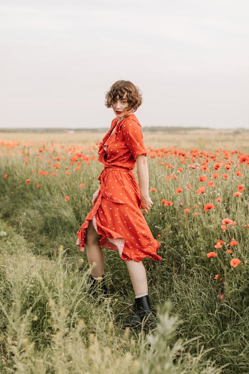 A Woman in Red Polka Dots Dress Posing in the Flower Field 