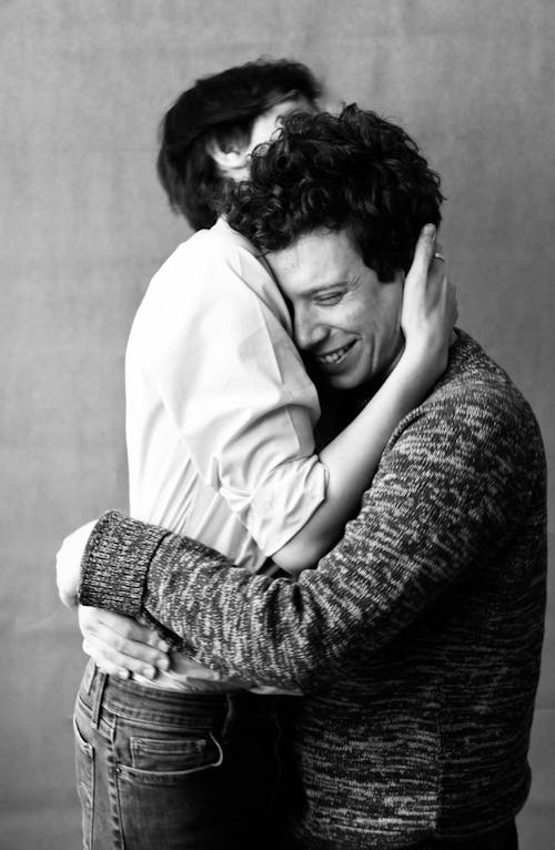 Black and White Photo of Two Men Cuddling