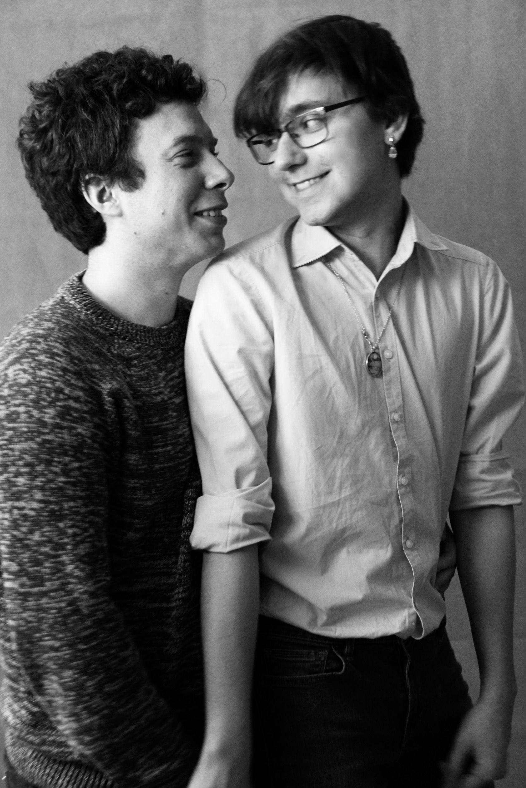 A candid black and white portrait of a smiling couple sharing a warm moment.