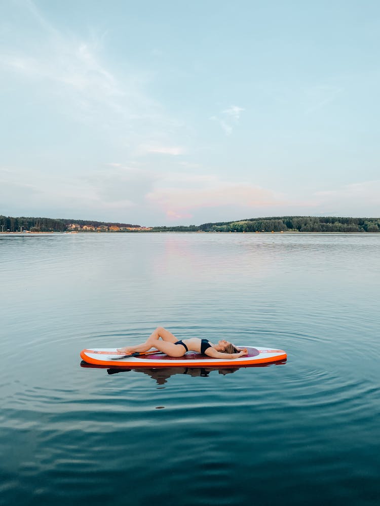 A Woman Lying On A Paddleboard 