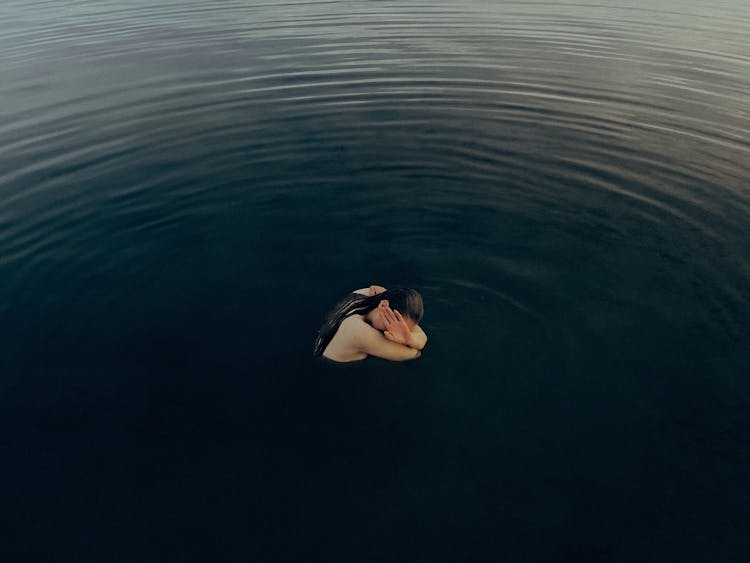 Woman In The Water Covering Her Face