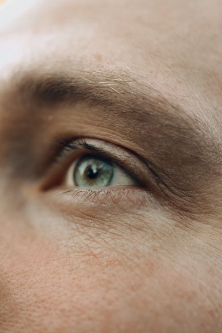 Detailed close-up shot of a human eye, showing surrounding skin and eyebrow.