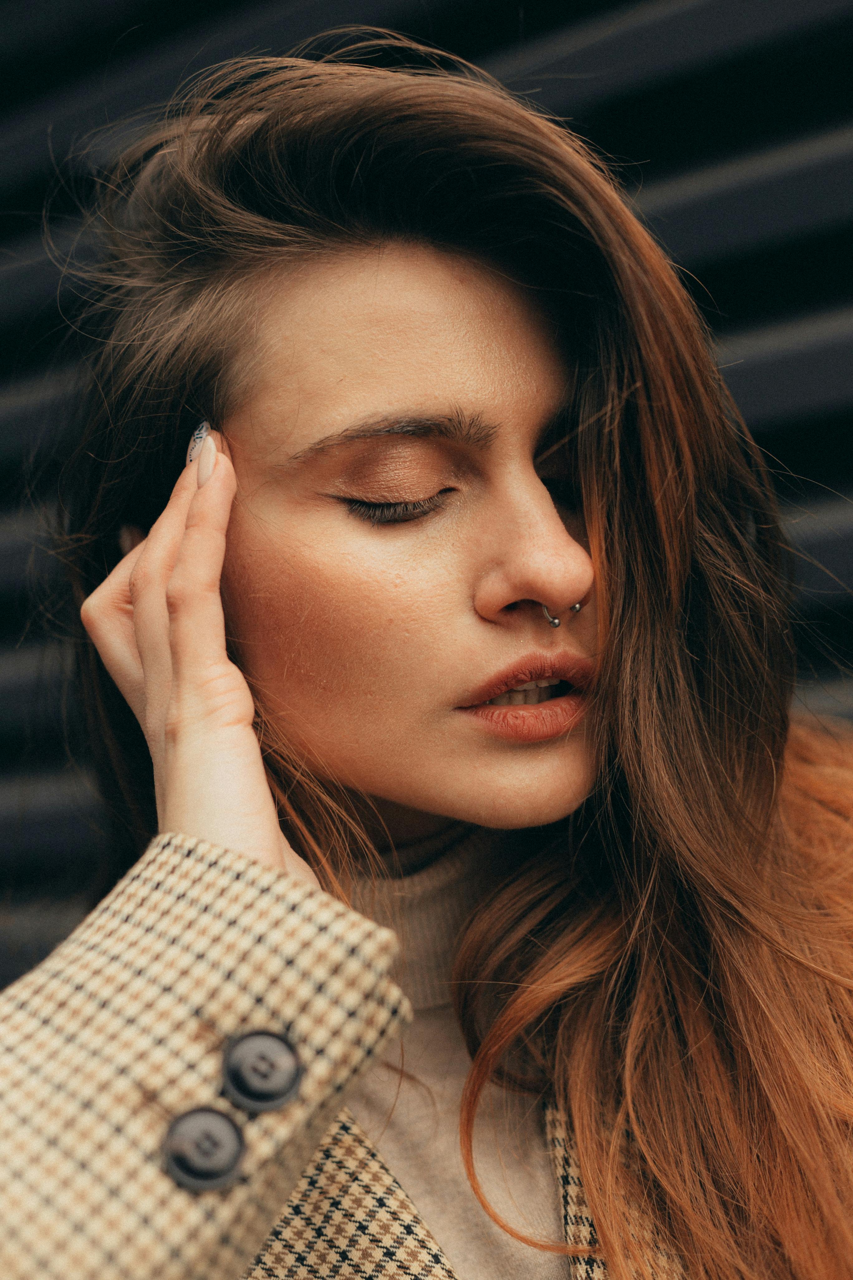 镜头特写一名年轻女子，她闭着眼睛，手放在脸上