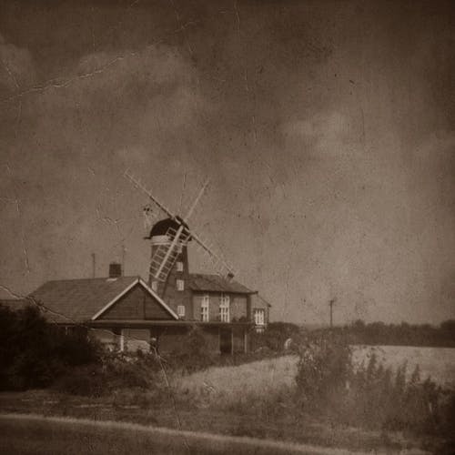 Classic Photo Of Wooden House With Windmill on Farm Field