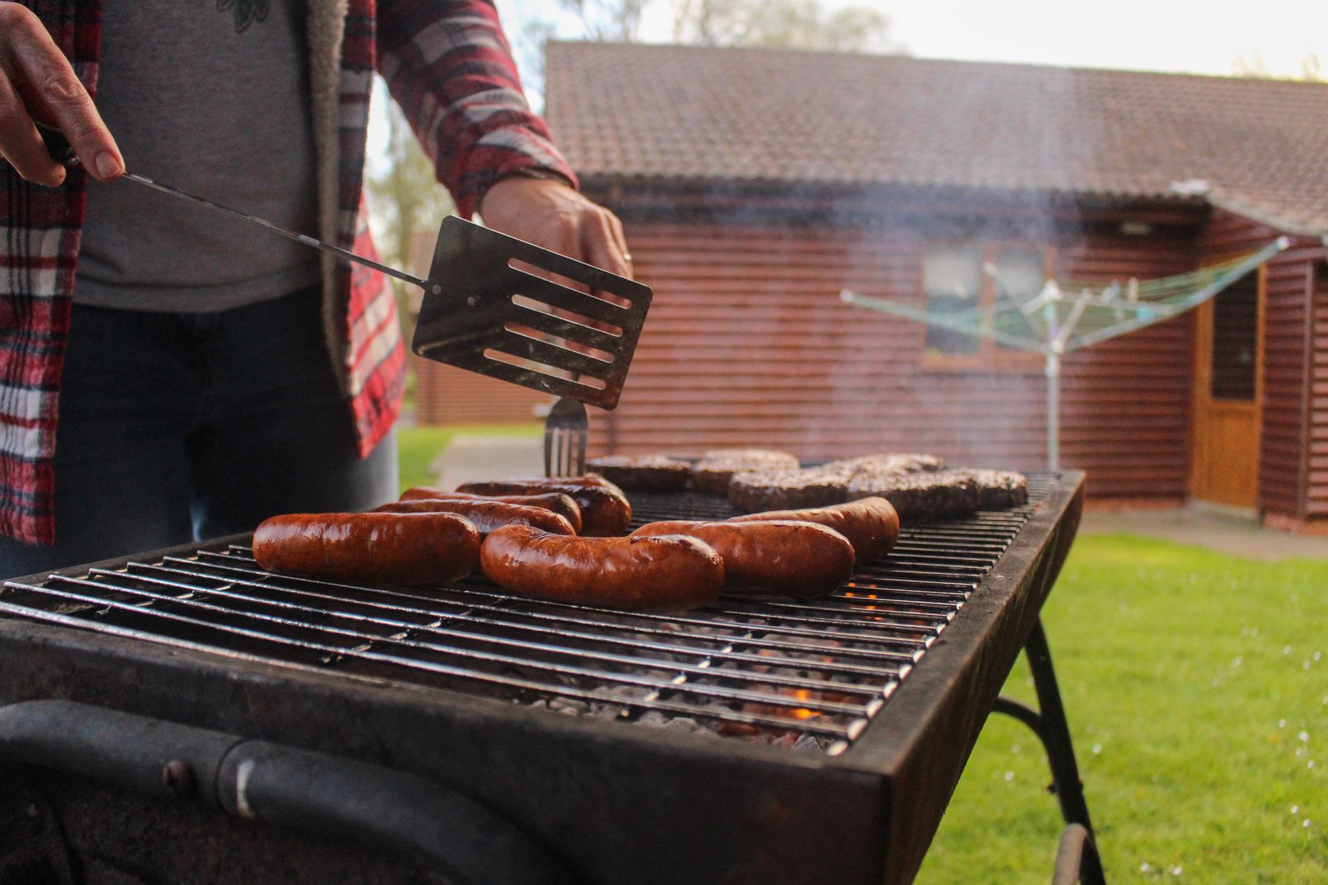 Barbecue met rook in een achtertuin bij een woning, bron van zomerse overlastmeldingen tussen buren