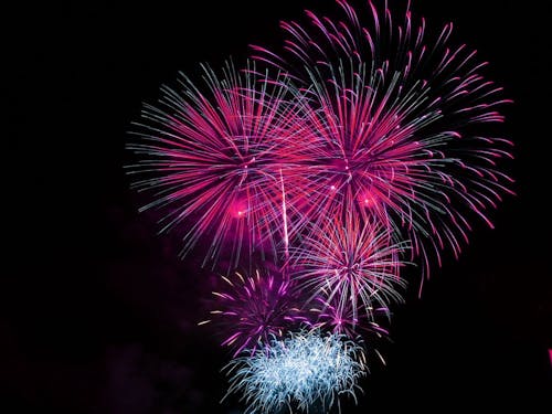 Pink and Blue Fireworks Display during Night Time