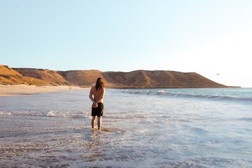 Calm man in shallow water of ocean