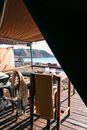 Paved veranda of luxury tent with set table in bright morning sunlight against ocean