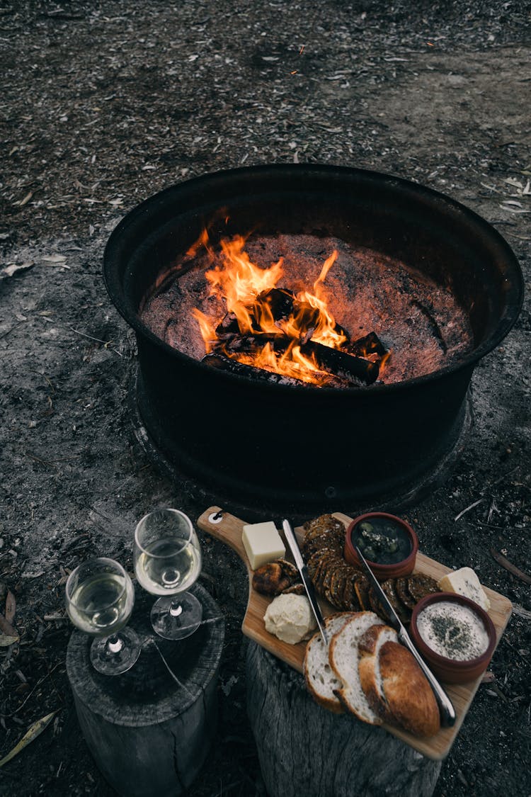 Fire Near Stumps And Snack With Glasses Outside