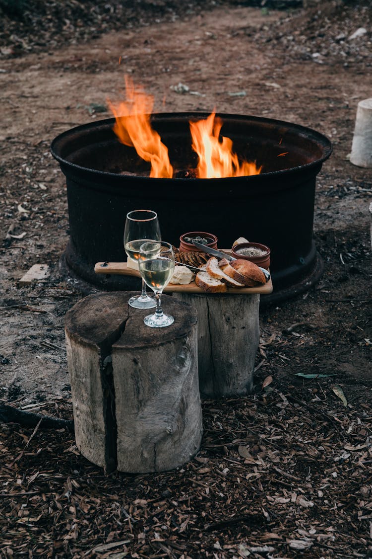 Fire Near Stumps And Snack With Glasses Outside