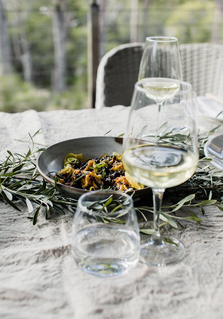 Bowl With Pasta And Wineglasses On Table