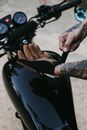 Faceless male standing near motorcycle with gloves