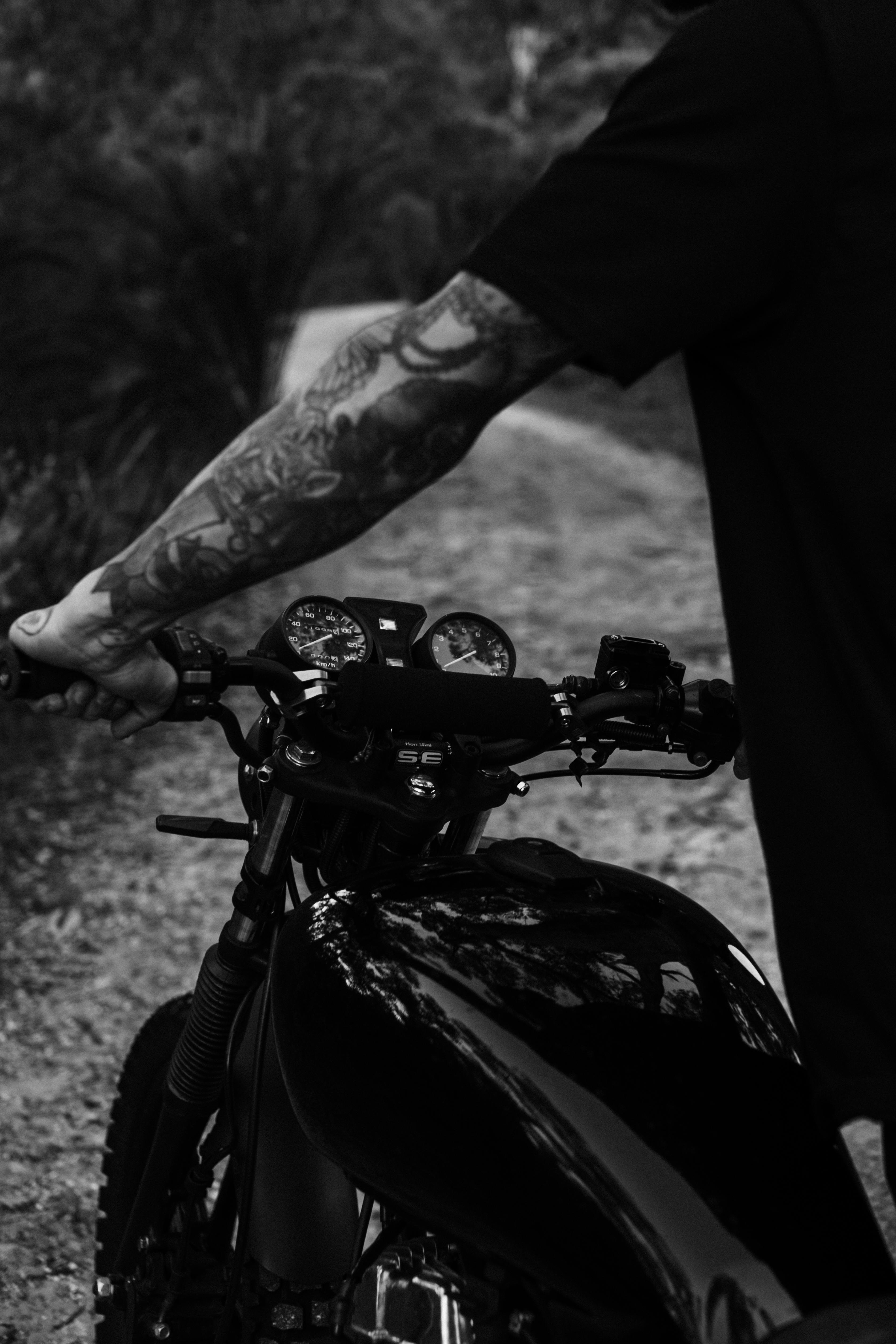 faceless biker standing with motorcycle on road