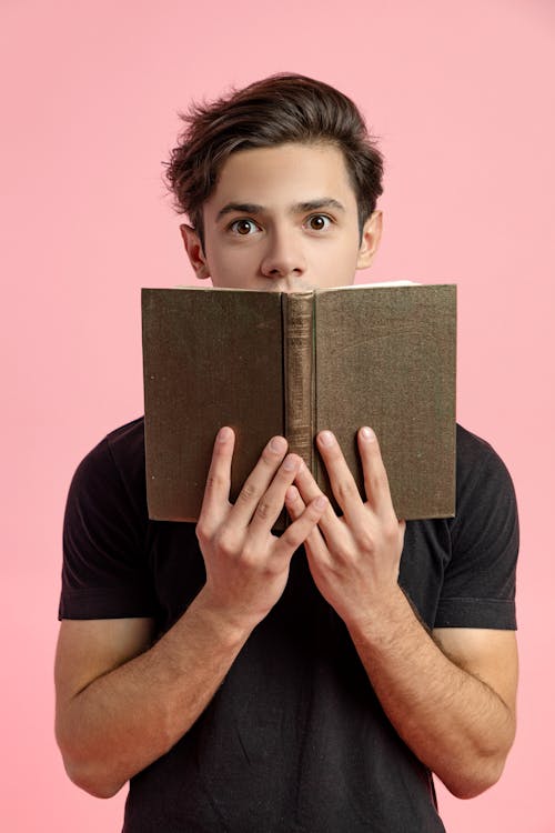 Amazed young man reading novel