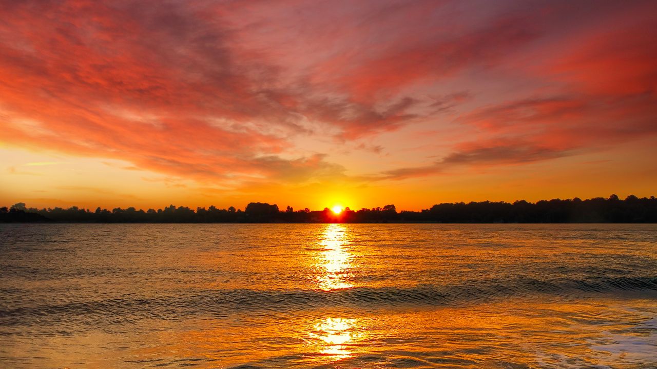 beautiful sunset with vivid colors reflecting over calm ocean waves pe