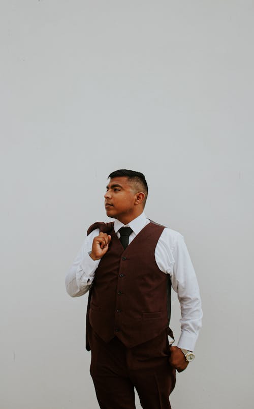 Free Fashionable man in trendy suit standing on white wall Stock Photo