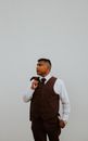 Fashionable man in trendy suit standing on white wall