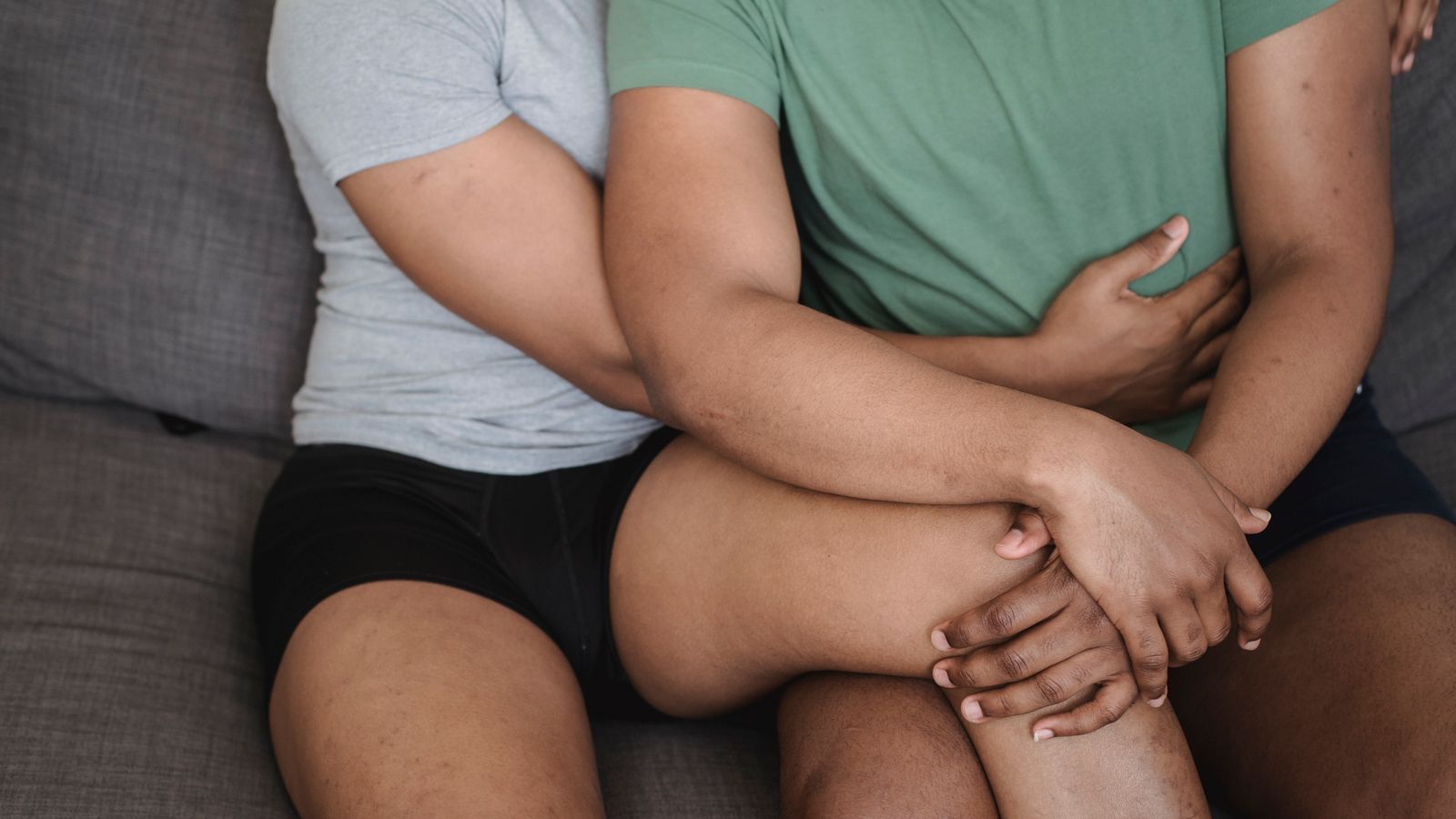 Two adults sitting close together on a sofa