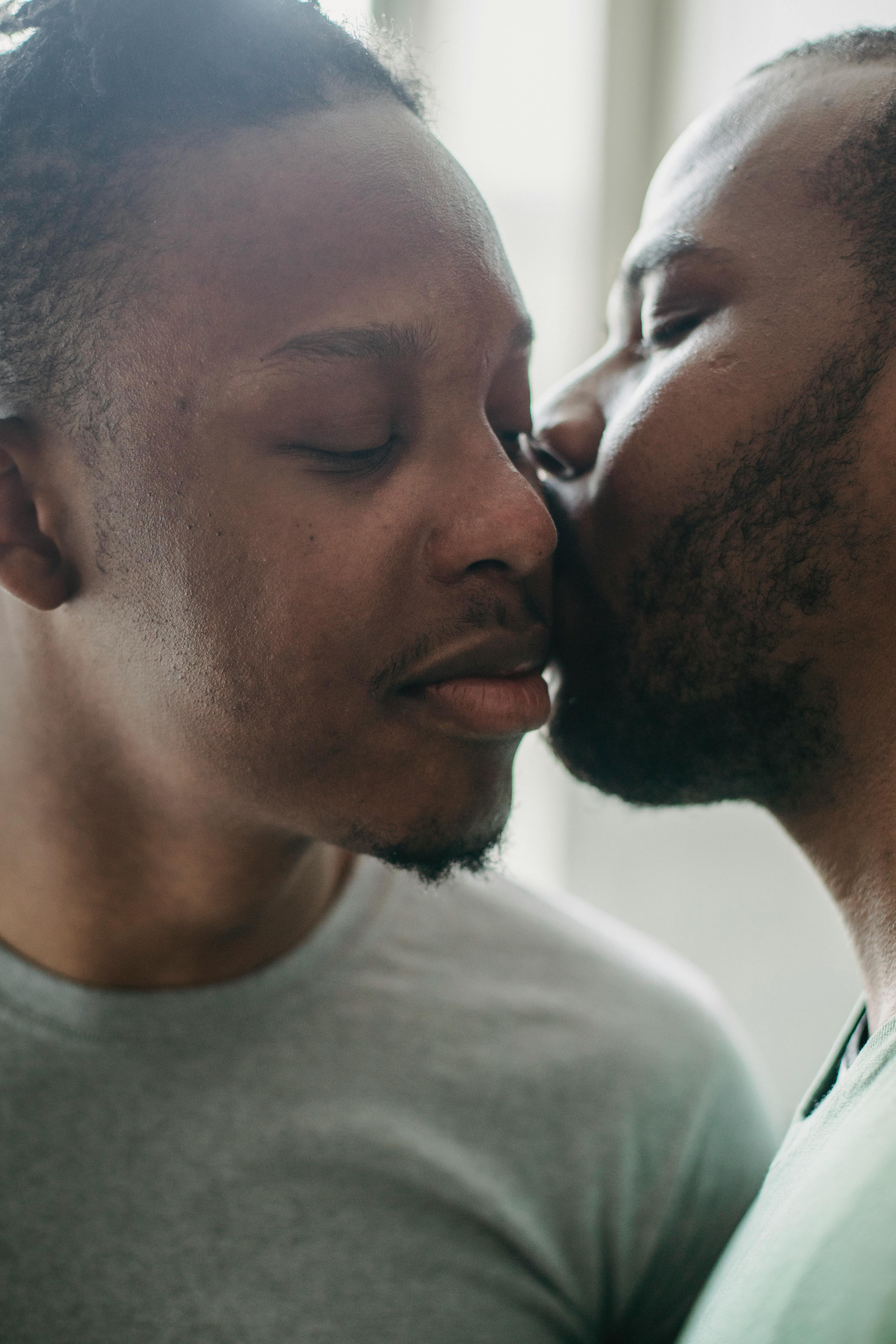 man kissing another man on the cheek