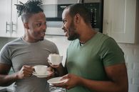 Man in Green Crew Neck T-shirt Holding White Ceramic Teacup