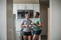 Couple Talking in the Kitchen and Drinking Morning Coffee